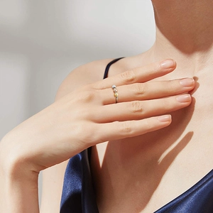 Detail of adjustable fidget ring with three-tone gold and silver spinning beads on finger