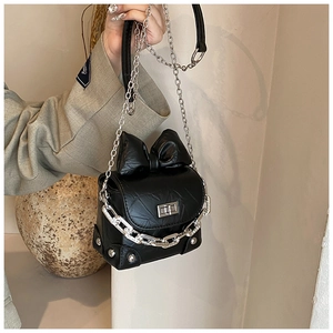 Detail of black pleated crossbody bag with large bow and silver metal chain strap