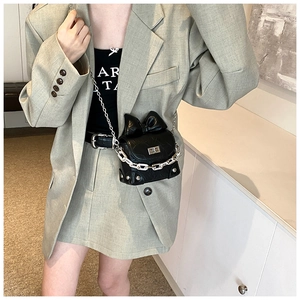Detail of black mini crossbody bag featuring a large bow and silver chain strap