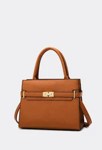 Détail du sac à main en cuir marron caramel avec fermoir rotatif et garniture dorée