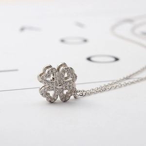 Elegant rotating four-leaf clover heart necklace with sparkling white rhinestones