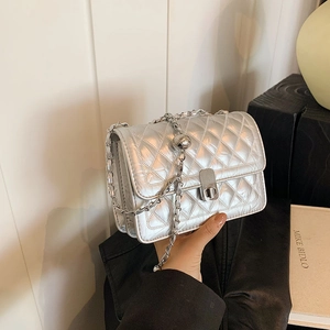 Silver quilted crossbody bag with metal chain strap and adjustable ball buckle