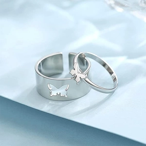 Gros plan des bagues de couple papillon en argent montrant le design imbriqué