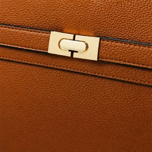 Détail du sac en cuir marron grainé avec un fermoir rotatif rectangulaire en métal doré