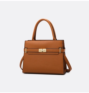 Détail du cuir grainé marron caramel avec fermoir rotatif en métal doré élégant