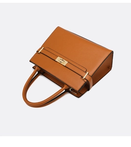 Détail du sac Kelly en cuir marron avec boucle dorée et poignée supérieure renforcée