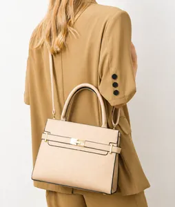 Mannequin portant un sac beige grainé avec boucles dorées et bandoulière amovible