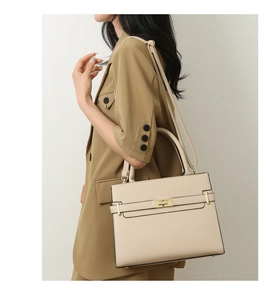 Détail du sac à main en cuir grainé blanc cassé avec fermoir rotatif doré et poignée