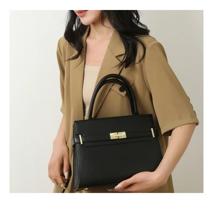 Vue détaillée du sac à main noir en cuir texturé avec fermoir en métal doré