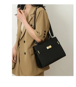 Détail d'un sac à main classique en cuir noir avec fermoir tournant doré élégant