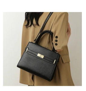 Détail du sac à main en cuir grainé noir avec fermoir doré et bandoulière amovible