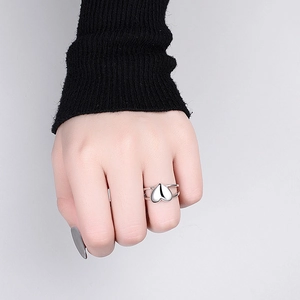 Detailaufnahme eines silbernen, doppellagigen Herzrings an einem Modellfinger