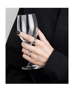 Detail von silbernem Doppelherz-Ring und Gliederketten-Ring Set an der Hand mit Glas