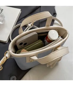 Vue intérieure du sac seau matelassé bleu clair montrant l'espace pour téléphone et portefeuille
