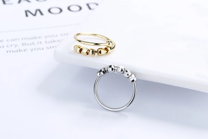 Detailed view of silver and gold anxiety fidget rings with movable faceted metal beads