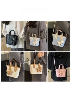 Sac seau matelassé en plusieurs couleurs avec breloque chien portée par un mannequin