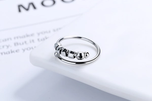Detail of adjustable spiral ring featuring five rotating hexagonal beads for stress relief