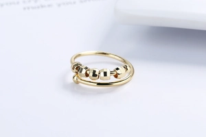 Detailed close-up of golden fidget ring with six faceted beads on adjustable open band