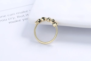 Macro shot of gold spinner ring featuring five faceted beads on a slender band