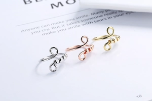 Detailed view of rotating silver, gold, and rose gold rings with hexagonal beads