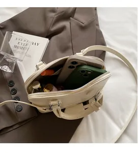 Interior view of off-white leather shell bag showing space for phones and cosmetics