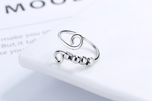Detailed macro view of silver spinner ring with four faceted beads for anxiety relief