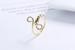 Close-up of golden spiral open ring with five multifaceted spinner beads for anxiety