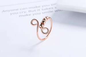 Macro shot of rose gold spinner ring featuring elegant swirls and refined metal beads