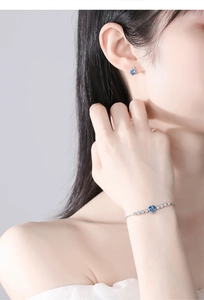 Detailed view of silver heart jewelry set with blue gems and micro-pave crystals