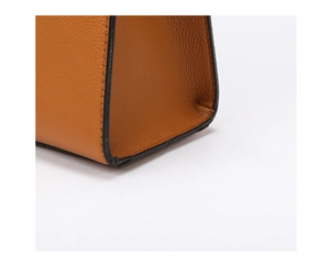 Vue détaillée du cuir grainé caramel et de la finition soignée des bords noirs du sac