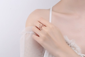 Detail of rose gold spinner ring with elegant swirls and beads on a model's hand