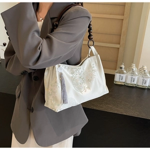 Detail of beaded wood handle and floral jacquard fabric on the off-white shoulder bag