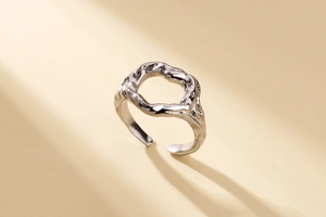 Gros plan sur la texture irrégulière et le fini métal liquide de la bague argent