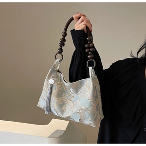 Detail of light blue floral jacquard fabric with beaded handle and elegant tassel