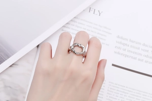 Gros plan d'une bague argentée à texture irrégulière portée au doigt au style minimaliste
