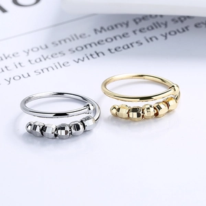 Spiral fidget rings with geometric beads in gold and silver for stress relief