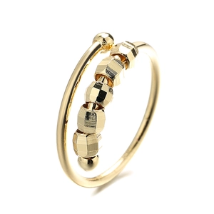 Gold spiral anxiety ring with six faceted beads for stress relief on white background