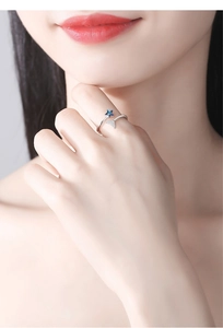 Detailaufnahme eines versilberten Rings mit blauem Sternkristall und Pavé-Dreieck