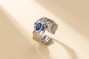 Detail of silver textured irregular lava ring with oval blue gemstone inlay