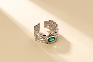 Detail of silver irregular lava ring with oval emerald zircon and textured finish