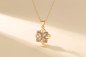 Close-up of gold-plated clover pendant necklace with marquise-cut sparkling zircons