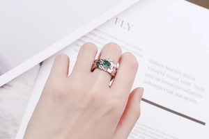 Irregular lava textured silver ring with an oval green zircon gemstone on a hand