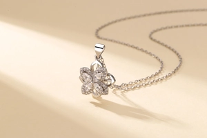 Detailed close-up of a silver four-leaf clover pendant with sparkling zircon inlays