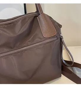 Close-up of deep brown canvas bag with lychee grain leather trim and metal zipper detail