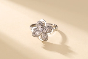 Macro shot of sparkling silver clover ring with marquise cut stones and pavé set petals