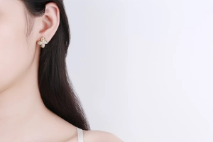 Close-up of sparkling gold four-leaf clover earrings with pavé-set cubic zirconia