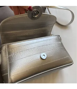 Détail du sac bandoulière argenté avec fermoir magnétique et cuir à texture gaufrée