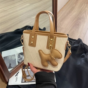 Sac seau matelassé élégant en cuir beige avec bordure marron et charm de chien mignon