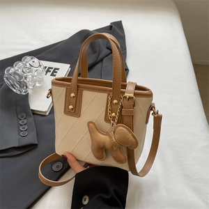Sac seau matelassé moderne avec bordure contrastée et breloque chien en main