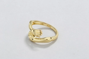 Detail showing S925 hallmark on inner band of gold plated hands hugging ring